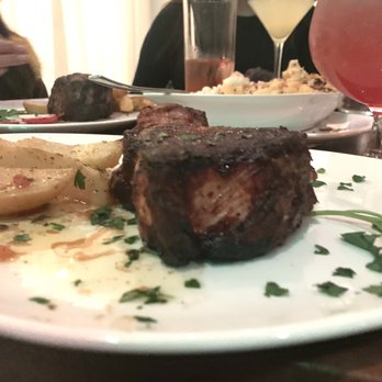 Limani Grille - Pork chop and steak in the back drop plus a white cosmo in the back - Mediterranean Near Me - Commack, New York Limani Grille - Pork chop and steak in the back drop plus a white cosmo in the back - Mediterranean Near Me - Commack, New York