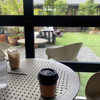 Seene House - Inside the main building where you order, looking across the outdoor space to the House, another sitting area with couches and work tables. - Coffee & Tea Near Me - Summerville, South Carolina