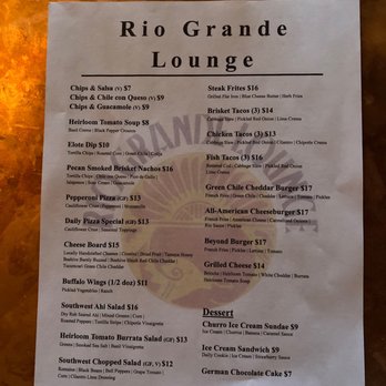 Rio Grande Lounge - Menu - The menu from Rio Grande Lounge displays a variety of food and drink options, including chips and salsa, steak fries, tacos, pizzas, burgers, salads, and desserts. Prices range from $7 to $17, with detailed descriptions of ingredients and preparation methods. The menu is printed on a single sheet of paper with a simple layout, listing items in categories such as appetizers, main courses, and desserts. - Lounges Near Me - Bernalillo, New Mexico