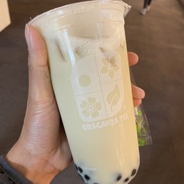 a hand holding a glass of milk tea a hand holding a glass of milk tea