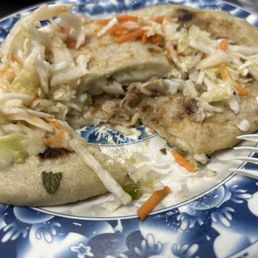 Revuelta pupusa con curtido (bottom) and pupusa de loroco (top) Revuelta pupusa con curtido (bottom) and pupusa de loroco (top)
