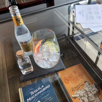 Reid's Distillery - Beautiful glass coffee table with cocktail books displayed. - Distilleries Near Me - Toronto, Ontario