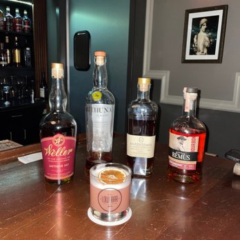 Low Bar - various bottles of alcohol on a wooden table - Cocktail Bars Near Me - Traverse City, Michigan