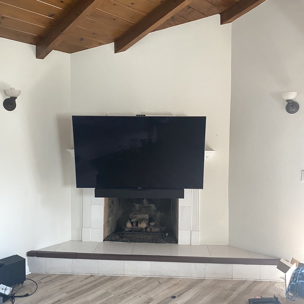 Elegant Mounting - Mount with the TV all the way down in front of the fireplace. - Home Theatre Installation Near Me Elegant Mounting - Mount with the TV all the way down in front of the fireplace. - Home Theatre Installation Near Me