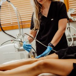 Columbia Laser Skin Center - Certified Advanced Aesthetician, Anna Lyons performing laser hair removal on her patient's lower legs.