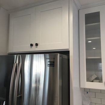 Construction Guaranteed - White Shaker kitchen cabinets around the fridge with glass front upper cabinets. - General Contractors Near Me - San Jose, California