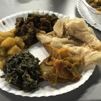 Curry Tabanca - My complete plate, with curried goat, potatoes, bhaji spinach, curried mango and roti. - Indian Near Me - Greenacres, Florida