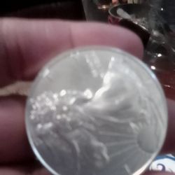 Merced Coin & Stamp - Silver coin encased I picture of eagle with a wing spread and the other side      a man with a long dress printed  1 oz silver