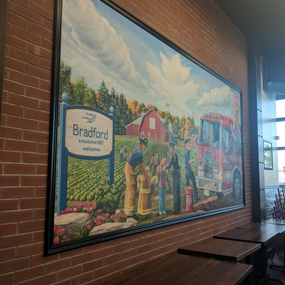 Firehouse Subs - a brick wall with a painting of a farm scene - Delis Near Me - Bradford, Ontario