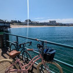 Beachside Bike & E-Bike Rentals & Repairs - Pink bike is the 26" Retrospec Cruiser Single Speed Step Thru (bike in the back isn't from Beachside)