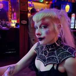 Goth clown in a great bar.