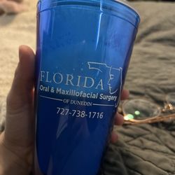A blue Florida oral & Maxillofacial surgery of Dunedin insulated cup filled with a delicious post op smoothie.