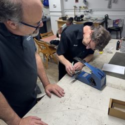 Alan gauging and punching a key as a customer looks on.
