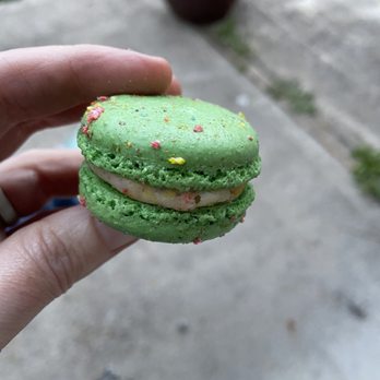 Lolli and Pops - a hand holding a green macaron - Chocolatiers & Shops Near Me - Tukwila, Washington