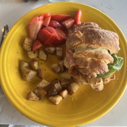 BLT croissant with potatoes and strawberries. BLT croissant with potatoes and strawberries.