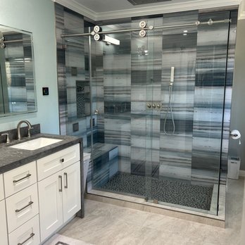 JDM Construction & Design - a bathroom with a glass shower - General Contractors Near Me