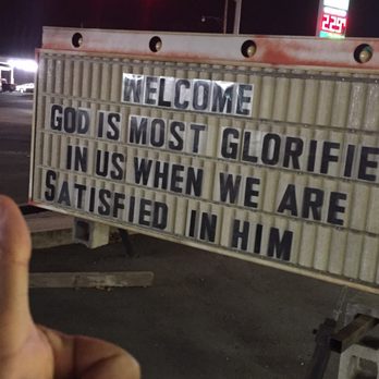 The Yellow Jacket Drive In - a hand pointing towards a sign that reads, welcome god is most terrified in us when we are satisfied at - Burgers Near Me - Sheridan, Arkansas