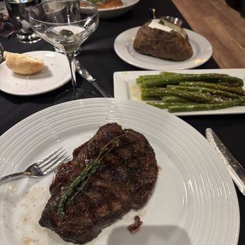 1889 Prime Steak House - 16 oz ribeye, sautéd asparagus, loaded baked potato and a dirty politician martini - Steakhouses Near Me - Olympia, Washington
