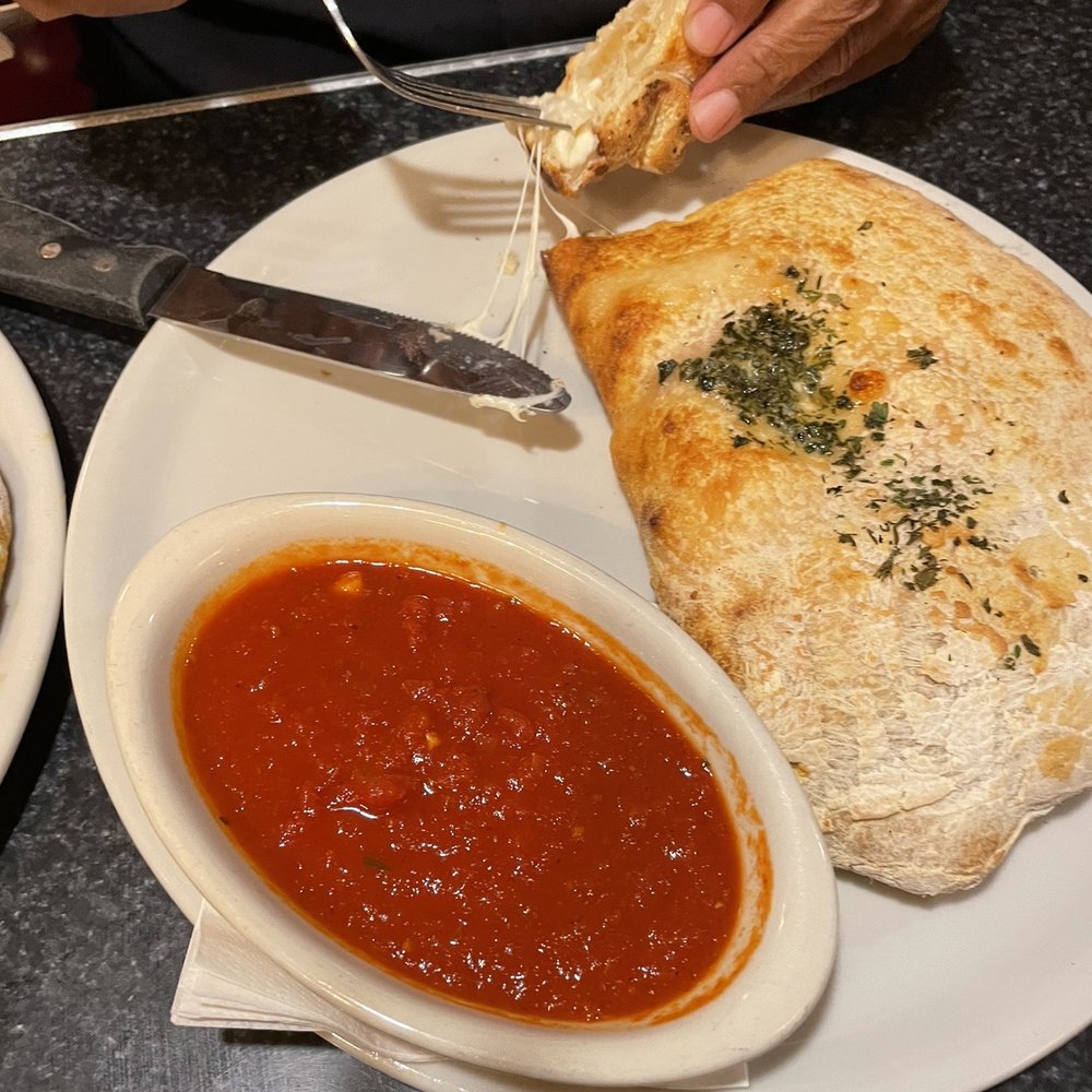 Regina Pizzeria - a person eating a piece of bread - Pizza Near Me - Burlington, Massachusetts Regina Pizzeria - a person eating a piece of bread - Pizza Near Me - Burlington, Massachusetts