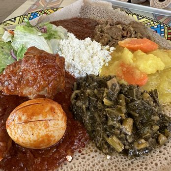 Lalibela - doro wat, beef alicha, minchet abish, atakilt wat, collard greens, salad, homemade cheese served on top of injera, - Ethiopian Near Me - Sioux Falls, South Dakota