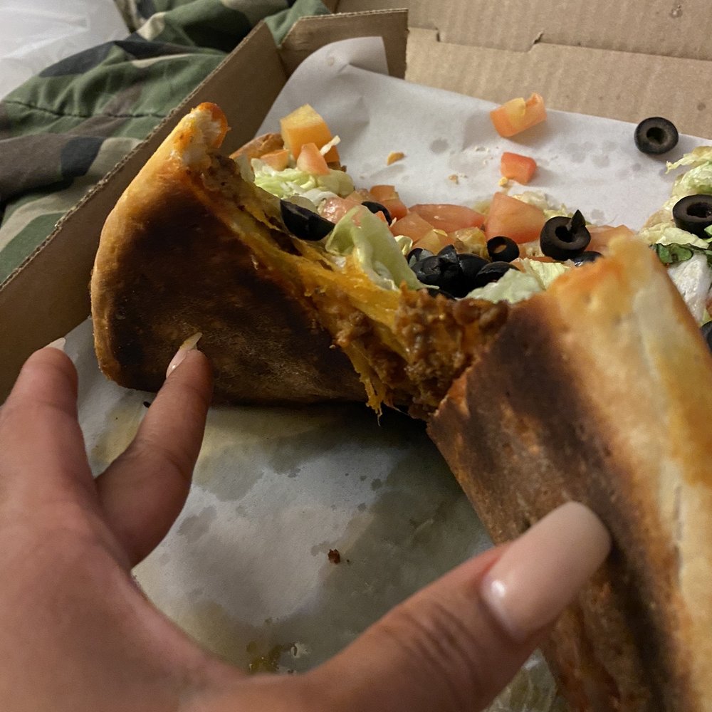 a hand holding a half eaten pizza a hand holding a half eaten pizza