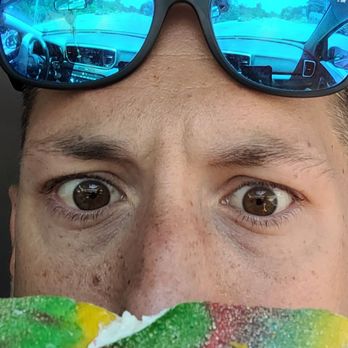 Bagel Toasterie - a man in sunglasses eating a bagel - Bagels Near Me - Commack, New York