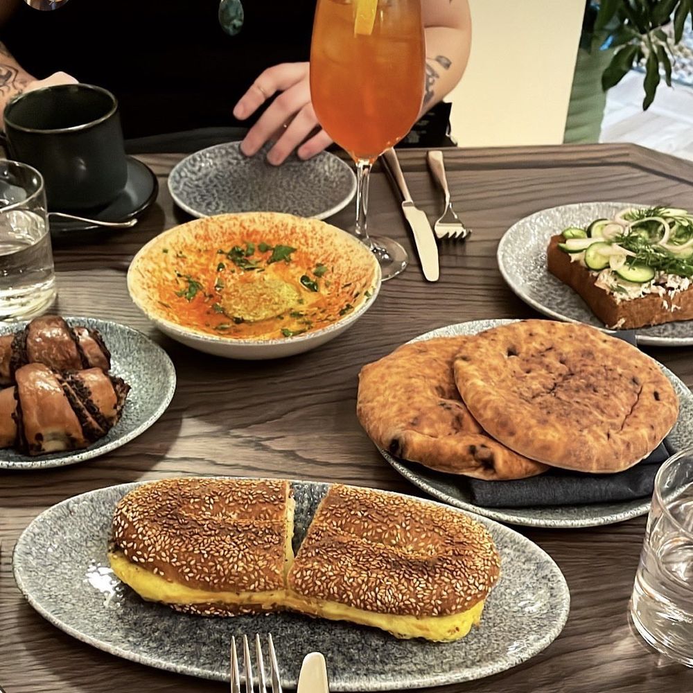 K'Far - Clock-wise  1. Hummus ($13) 2. Smoked Trout Kubaneh ($14) 3. Jerusalem Bagel Egg and Cheese ($13) 4. Chocolate Rugelach ($7) - Breakfast & Brunch Near Me - Brooklyn, New York