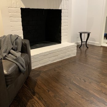 The Golden Hardwood Floors - a living room with a fireplace - Flooring Near Me