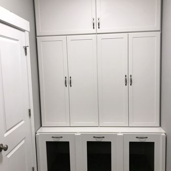 Custom Closet Geeks - Custom Dog Kennel - A set of white built-in cabinets with upper and lower storage compartments, featuring metal handles and mesh-front doors on the lower section. - Home Organization Near Me - New Bedford, Massachusetts