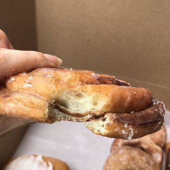 Looney Baker - a hand holding a half eaten doughnut - Donuts Near Me - Livonia, Michigan Looney Baker - a hand holding a half eaten doughnut - Donuts Near Me - Livonia, Michigan