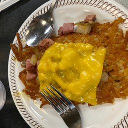 a plate of hash browns and a fork