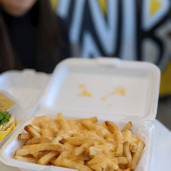 WNB Factory - a tray of macaroni and cheese fries with a woman in the background - Chicken Wings Near Me - Duluth, Georgia