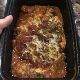 a person holding a pan of pizza