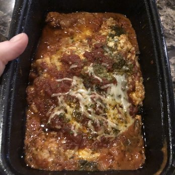 Glass Nickel Pizza - a person holding a pan of pizza - Pizza Near Me - Appleton, Wisconsin