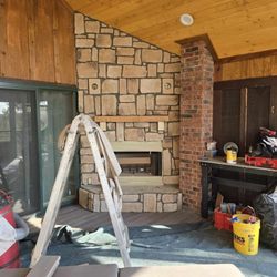 Lakeside Chimney - Covered deck we built a hearth in the corner, installed a wood burning fireplace, stone veneer, wood mantle, electrical outlet & lamps. 2/3