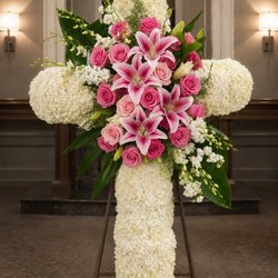 A beautiful custom sympathy cross designed with white hydrangeas, pink roses, and stargazer lilies to honor a life with love and grace. At A