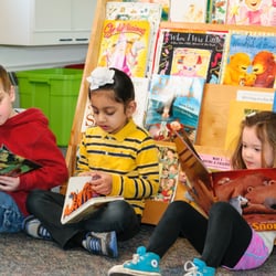 Lakehill Pre-School - "Reading" after snack time. Children practice reading by looking through our ever changing selection of books.