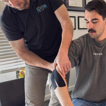 Spinal Axis Chiropractic - Dr. Bradley Foster placing Kinesiology Taping on a patient at Spinal Axis Chiropractic in Chico, CA - Chiropractors Near Me - Chico, California