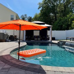 Wise Pool & Spa Service - Freeform inground swimming pool with raised wall and water feature, and Wet Edge Signature Matrix Cadet Blue interior finish.