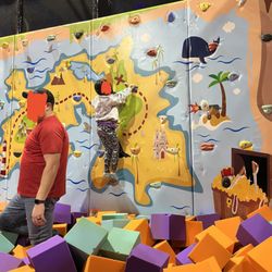 Go play! - Rock wall! The other half of this room is trampolines for jumping into the pit