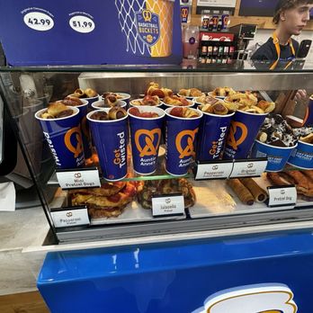 Auntie Anne's - Auntie Anne's Pretzels display case shows pretzels, mini pretzel dogs, and jalapeño pretzels with branded cups and labels. - Pretzels Near Me - Mashantucket, Connecticut