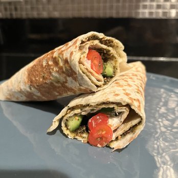 Thyme Machine - Labneh & Za'atar with all the veggies (to go) - Two wraps filled with vegetables, cherry tomatoes, and herbs are placed on a blue plate, showcasing Lebanese cuisine. - Lebanese Near Me - Miami, Florida