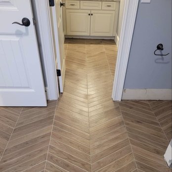 Santizo - a bathroom with a herring tile floor - Flooring Near Me - Cary, North Carolina