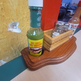 Bullet hole in wall - next to some really hot hot sauce