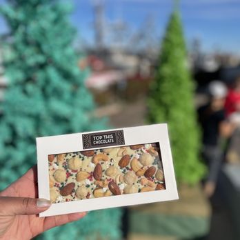 Top This Chocolate - a hand holding a box of nuts - Chocolatiers & Shops Near Me - Ventura, California Top This Chocolate - a hand holding a box of nuts - Chocolatiers & Shops Near Me - Ventura, California