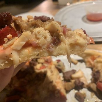 Jo's Famous Pizza - a hand holding a piece of pizza - Pizza Near Me - Edmond, Oklahoma Jo's Famous Pizza - a hand holding a piece of pizza - Pizza Near Me - Edmond, Oklahoma