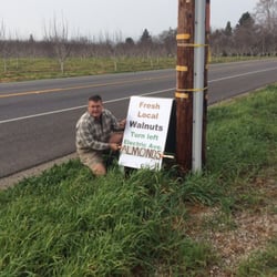 Warfield Farms - Warfield Farms sign with owner kneeling next to it.