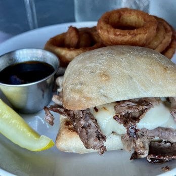 Idletyme - Shaved prime rib sandwich ($17) with onion rings (+$4) - American Near Me - Stowe, Vermont Idletyme - Shaved prime rib sandwich ($17) with onion rings (+$4) - American Near Me - Stowe, Vermont