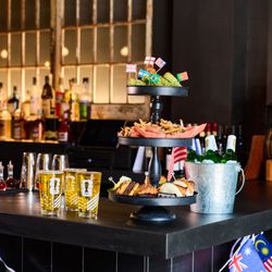Food tower and Pitch-Side Pail on the bar at BLACKBARN's Tavern, 19 East 26th Street, NoMad, NYC, with international flags fo...