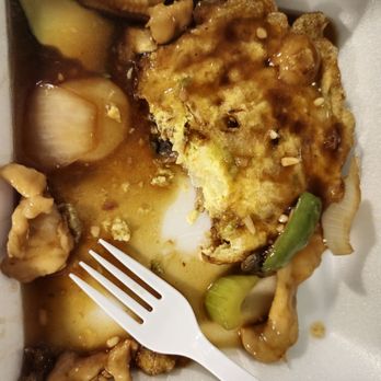 Lucky Wok - Chicken Egg Foo Young - A takeout container holds a partially eaten chicken egg foo young with vegetables and sauce, including green onions and mushrooms. - Chinese Near Me - Albuquerque, New Mexico